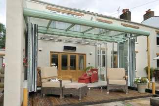 The glazing bars in the roof over-sail and carry the glass with it, creating a roofing canopy where homeowners can sit in the garden yet be protected from the