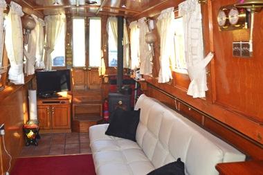 All interior wood has been varnished. There are curtains or blinds to all windows. SALOON 11 8 Wooden,! glazed front doors, open out onto the front deck with storage steps down into the saloon.