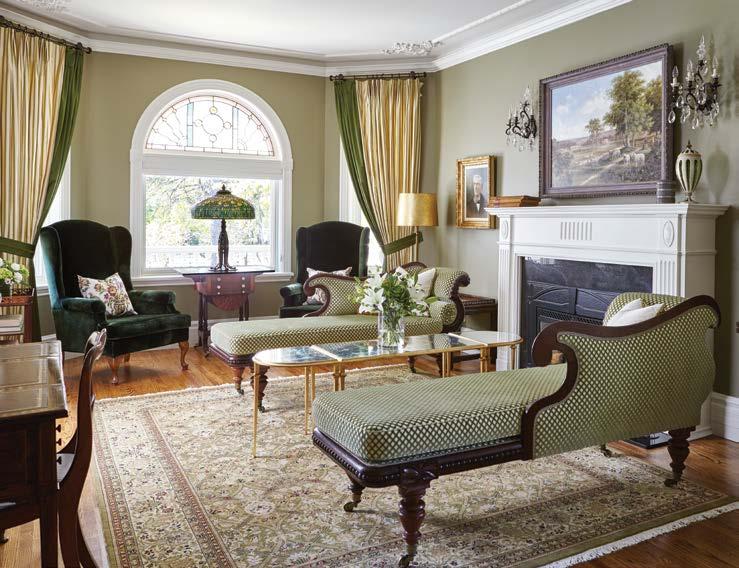 A dramatic pair of cream and moss green silk drapes flank the arched window.