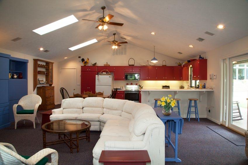 Separate guest house by the pool features an open concept family room and a full kitchen.
