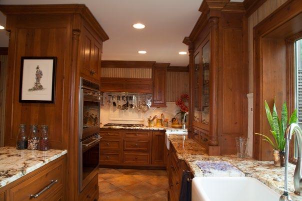 A china cabinet with glass doors is between the 24 sink and a 30 Rohl farm sink that serves