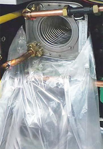 Use a large plastic bag to cover the all the other heat exchanger assemblies below the one being removed, as shown in Figure 3-5.