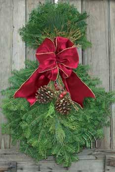 The Balam Fir Claic Wreath i tatefully decorated with a long tailed, gold-backed velveteen bow and white
