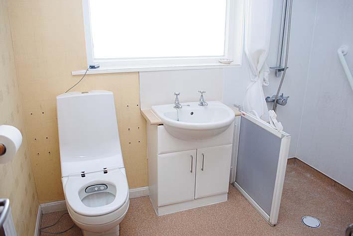 WET ROOM Sealed specialist vinyl flooring, electric shower with curtain and low dividing gate and Aqua board in shower area, extractor fan, Specialist white W.C.