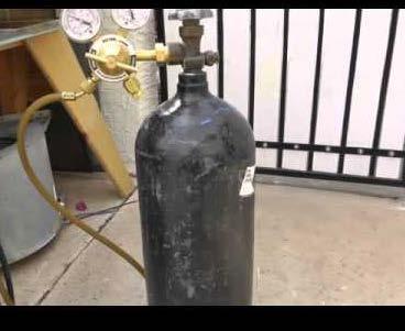 8. Connect a pressurized DRY air or DRY nitrogen source to the distribution hose that was removed from the discharge adapter on the extinguisher assembly.