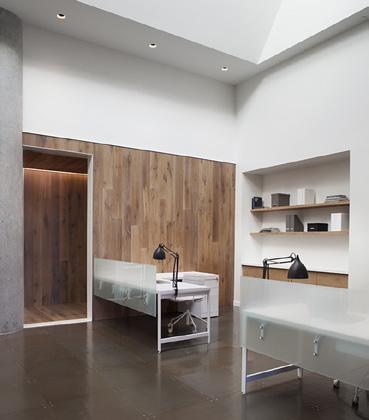 lobby, employees and guests alike step through a continuous wood-clad wall with a pivoting door to a warm, light-filled
