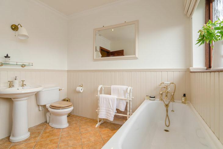 BATHROOM: White suite comprising panelled bath with mixer tap and telephone hand shower, low flush wc, pedestal wash hand basin,
