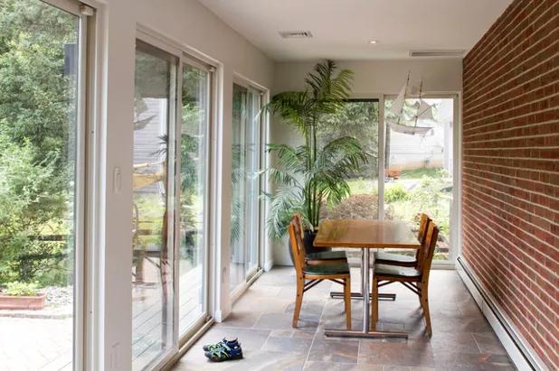 12/15/2018 Houzz Tour: Midcentury Ranch Addition Blends In and Looks Outward Past the angled cabinets in the previous photo is a glimpse of this sunroom.