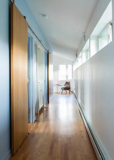 row of clerestory windows provides light for the hallway while maintaining privacy from the street. The chair marks the entrance to the boys study.