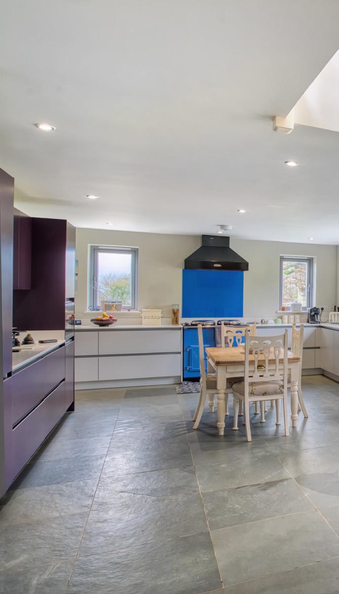 KITCHEN/ LIVING Slate floors run throughout the ground floor, with grey kitchen units, pale walls and lots of glass.