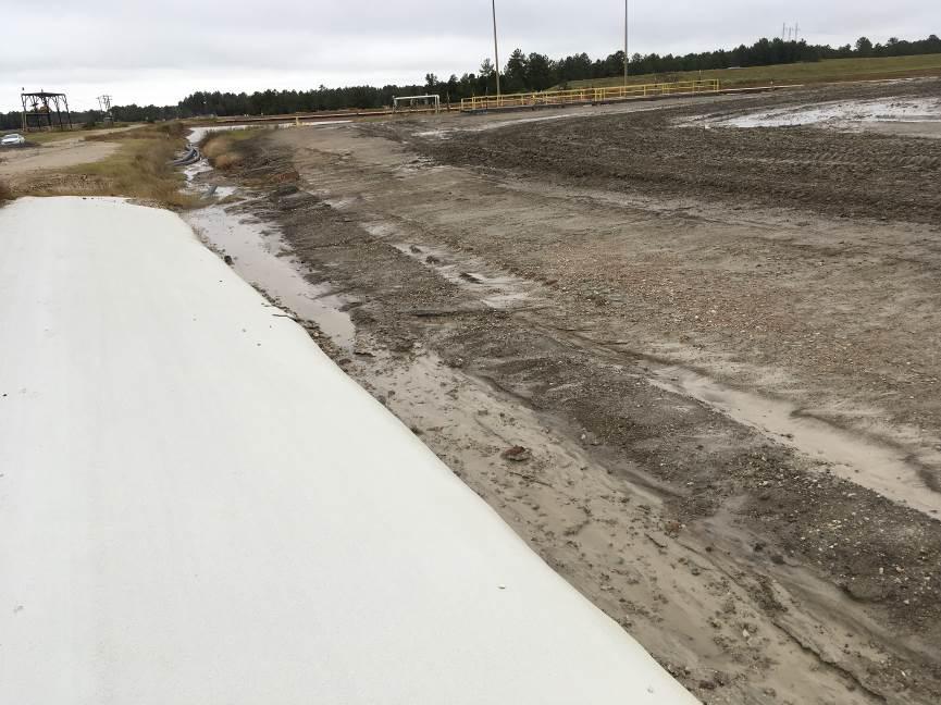 gravel berm with a geomembrane cover, facing