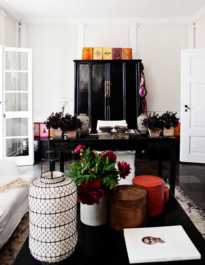 Paper lanterns from Tibet top an antique cabinet: together with a Vietnamese kimono, round boxes from Burma and peonies in bloom, they add