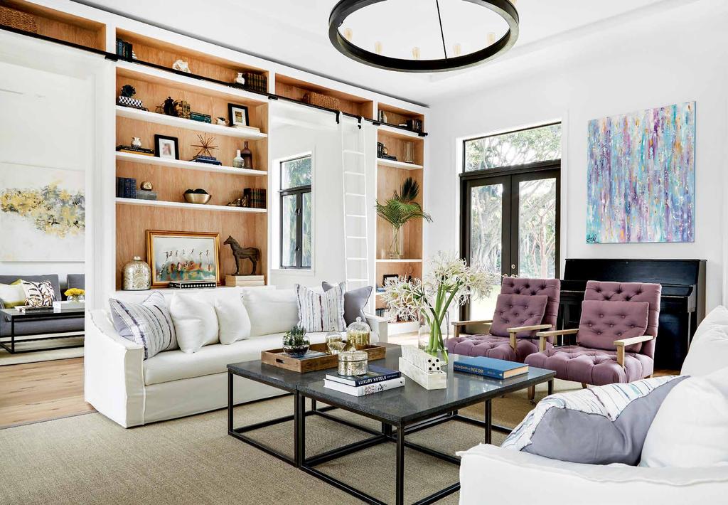 The scene is grounded by a sisal Fibreworks rug from The Carpet Boutique, and overlooking the space is a painting by Laura Concha from the owners collection.