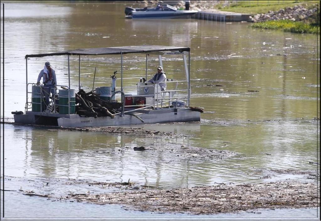 Department workers use utility boats to remove some of the debris including tires,