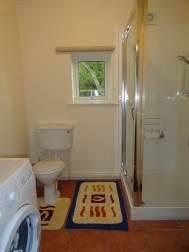 05m) having a white suite comprising a tiled/glazed shower cubicle with a fold down wall seat, a Bristan shower and a glazed entrance door, a pedestal