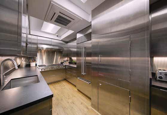 boasts plentiful stainless-steel cabinets, a sink, a six-burner Wolf cooktop with a grill, two Wolf ovens, a