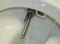 To do this insert the special tool supplied hook end into the recess at the bottom of the douche arm (arrow).