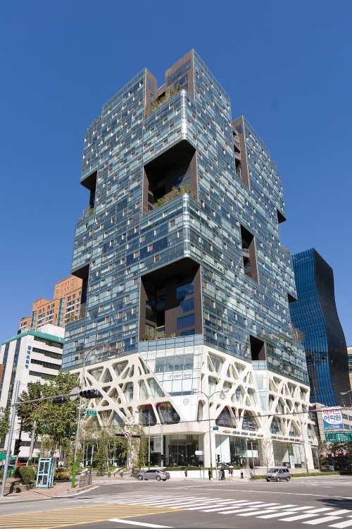 The architect of this building, Jo M in-seok, came up with the idea to make spaces in the building structure in order to comply with regulations regarding floor-area ratio, while keeping the planned