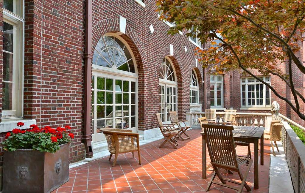 French doors from the main level solarium open to the terracotta tiled rear terrace and breathtaking expanse of the