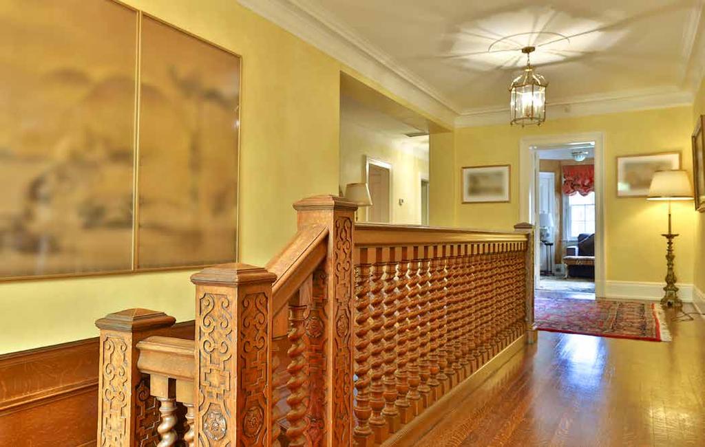 An intricately carved banister with solid wood, candy cane turned spindles