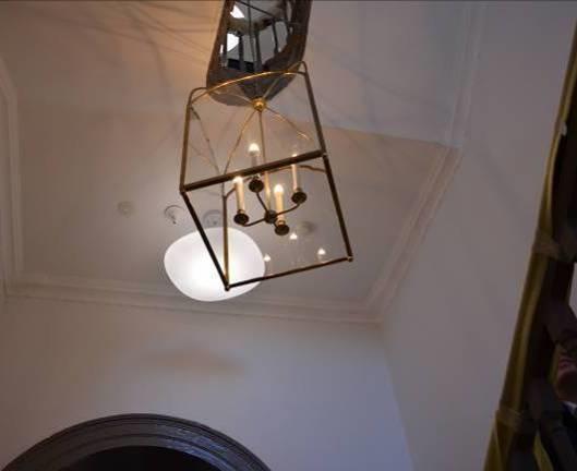 Traditional lantern light fitting centre piece of the curved stairwell at the heart of the building Detail of refurbished fireplace with hand-crafted