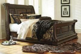 birch veneers and hardwood solids in a deep brown color with metallic detailing Bedroom adorned with ornate details, grand scale, and natural marble tops Gracious curving sleigh bed is centerpiece of