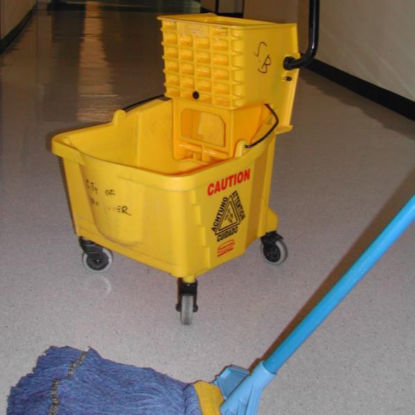 They put the bristle part of the push broom over a scuff mark, put one foot on the bristle, and then move their foot side to side with enough pressure to erase the scuff mark.