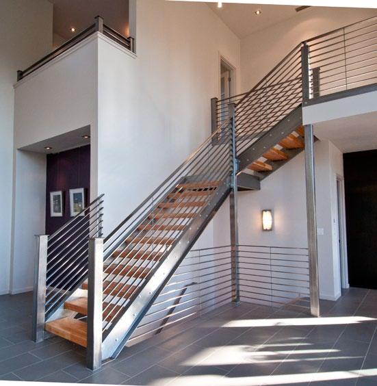 HOME The floating steel staircase with a frosted glass landing adds an industrial edge to the space.