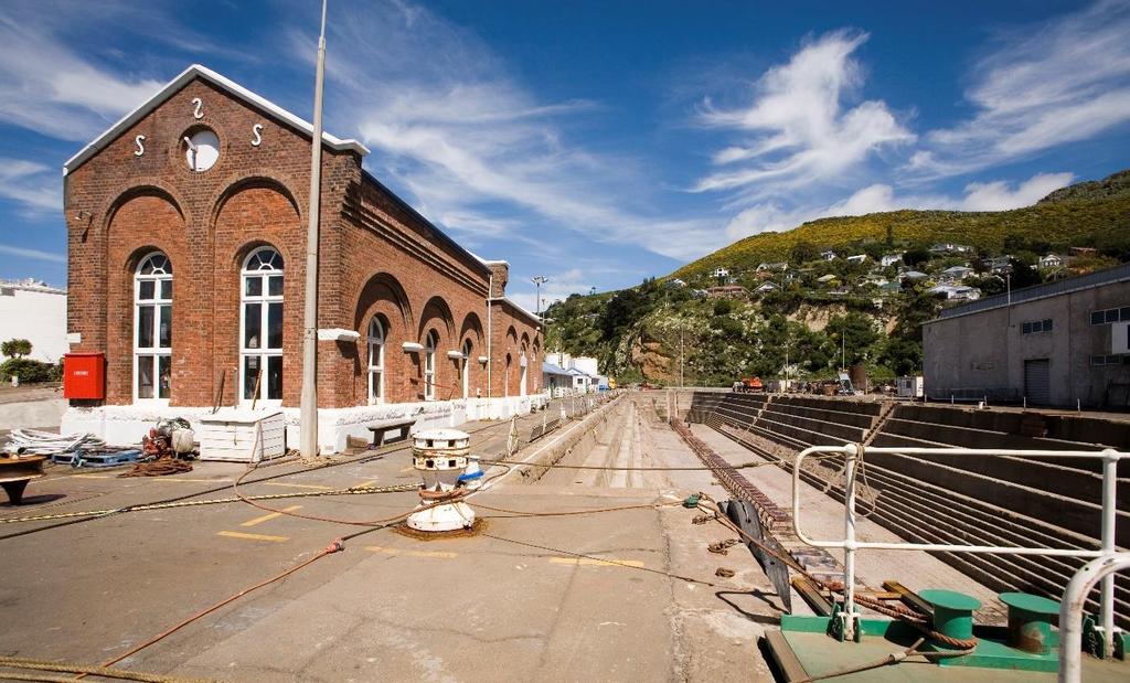 Figure 6. At left, the pumphouse prior to demolition, with the graving dock to the right. Photograph courtesy of Hal Upton.