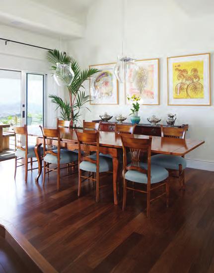 The dining room is furnished with contemporary art and hurricane glass pendant lights