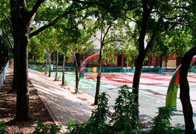 Colorful painted basketball courts and a tree-shaded, paved slope for sitting and watching games combine to make a simple, attractive, and functional space at Belafonte-Talcolcy Park.