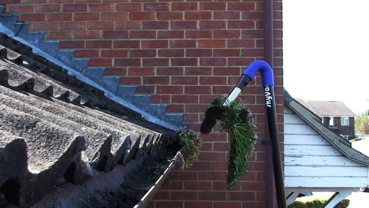 Best practice to remove heavy tufts of grass from gutters is chop down to manageable lengths.