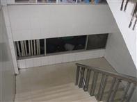 Photograph: (1) Office area open to exit stair (2) Non-rated glass opening into stair Provide fire-resistive rated construction barriers for exit enclosures in accordance with Alliance Standard