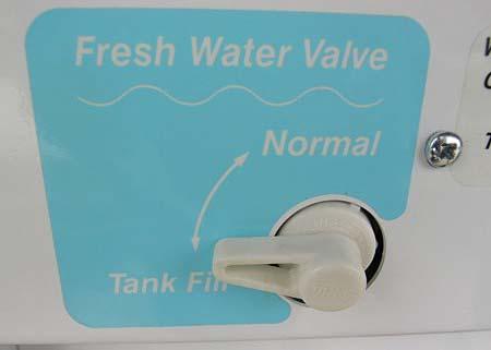 The tank is filled through the city water connection (Fresh Water Inlet) or optional hose reel in the water center.