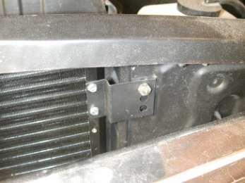 Slide condenser assembly between radiator bulkhead and the grille assembly. Locate over the radiator mounting studs.