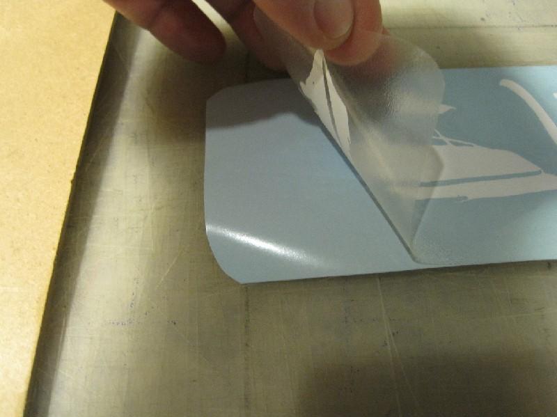 Now, try pulling up the sticky tape from the blue backing very slowly. It should come up with the vinyl decal attached to the clear tape.