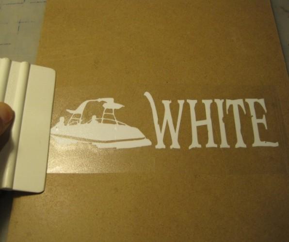 Next, run the rigid object (credit cards work fine) over the tape and decal to press out any air bubbles that might be