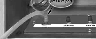 Connect one side of a manometer or pressure gauge to the manometer pressure port (barbed) on the pressure test manifold (located inside control panel). See Figure 18.