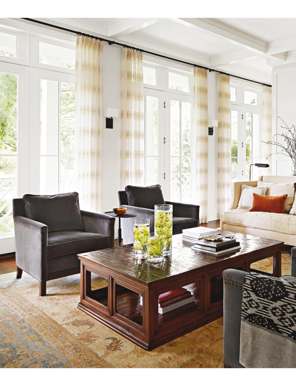 THIS PHOTO: Linear shapes abound in the light-filled living room. The elongated lines of paneled walls echo the configuration of the doors and transoms as well as the coffered ceilings.
