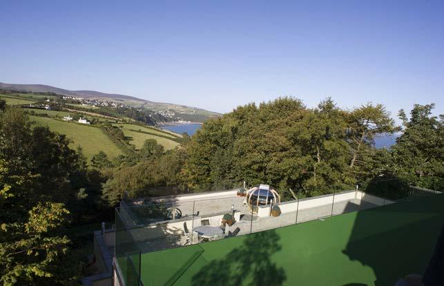 To the rear is a raised deck area of approximately 100 square metres surfaced in putting-green effect allweather carpeting with stainless steel and clear glazed balustrading, affording