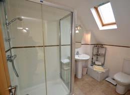 controlled shower unit, glass shower screen, fully tiled walls, extractor fan, tiled floor.