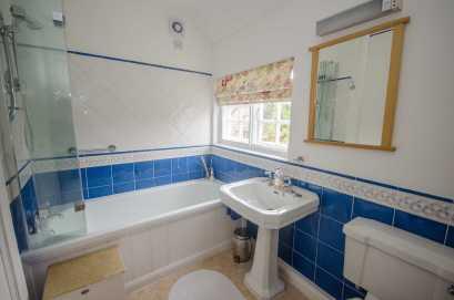 glazed shower screen; pedestal wash hand basin; and low level WC Part-tiled walls, secondary glazed window overlooking Windmill Lane, extractor, ceiling light point, wall light with electric shaver