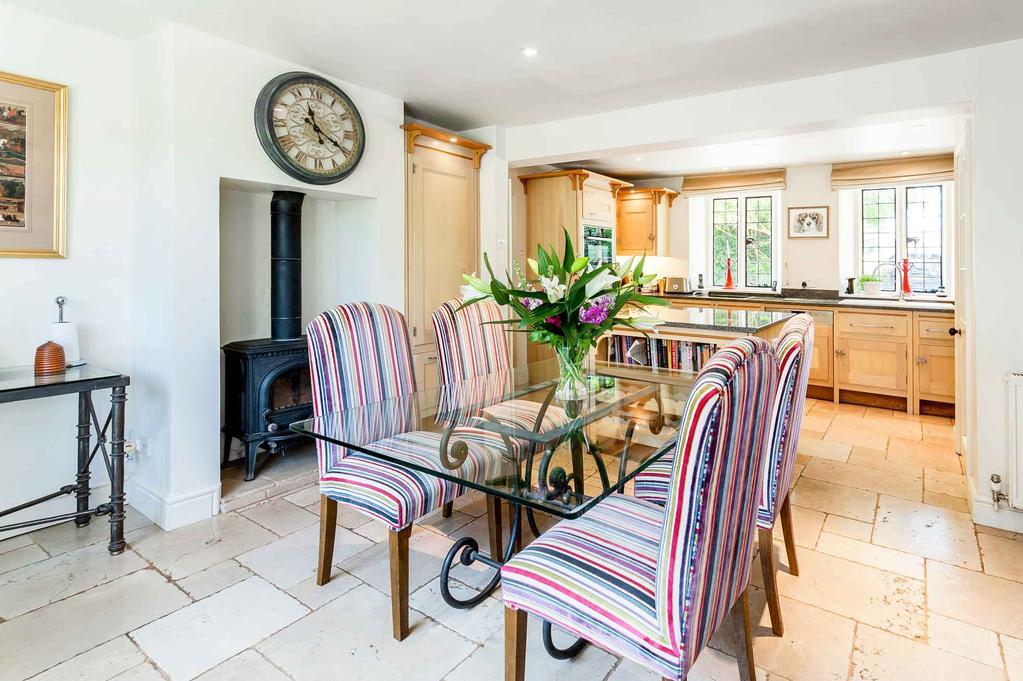 At one end of the hall lies a large sitting room with feature fireplace, oak floors and access to the garden room with views over the gardens and paddock.