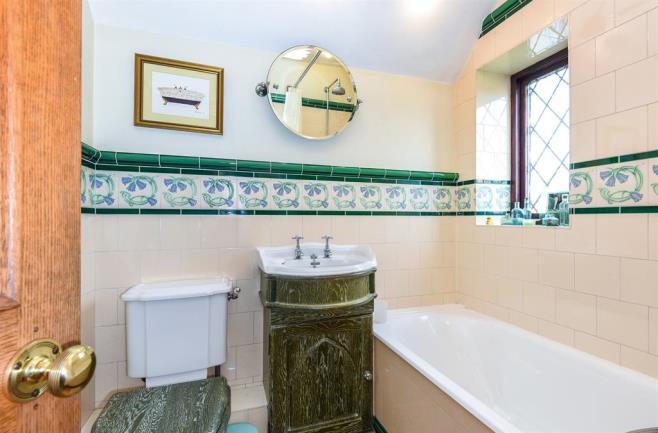 HOUSE BATHROOM Tiled bath with shower over, tiled walls and floor, wash hand basin and w/c.
