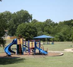 The park is bordered on one side by a single-loaded road and on the other by the wooded Red Oak Creek corridor.