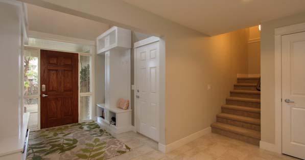 Carpeted stairs with mid-level landing, wood banister and metal spindles Ceiling fan and wall sconce lighting Windows to side and front yard for natural light Small desk area at top of stairs