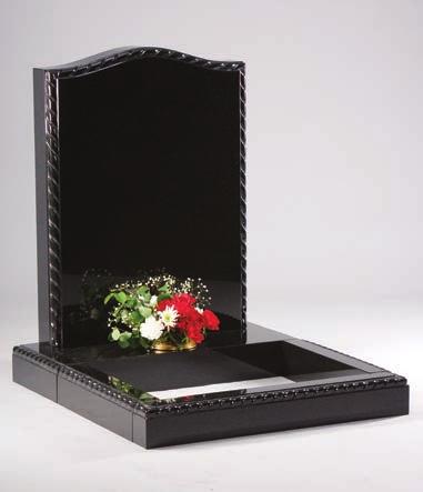 A tablet headstone sitting on a base which has a vase in the rest.