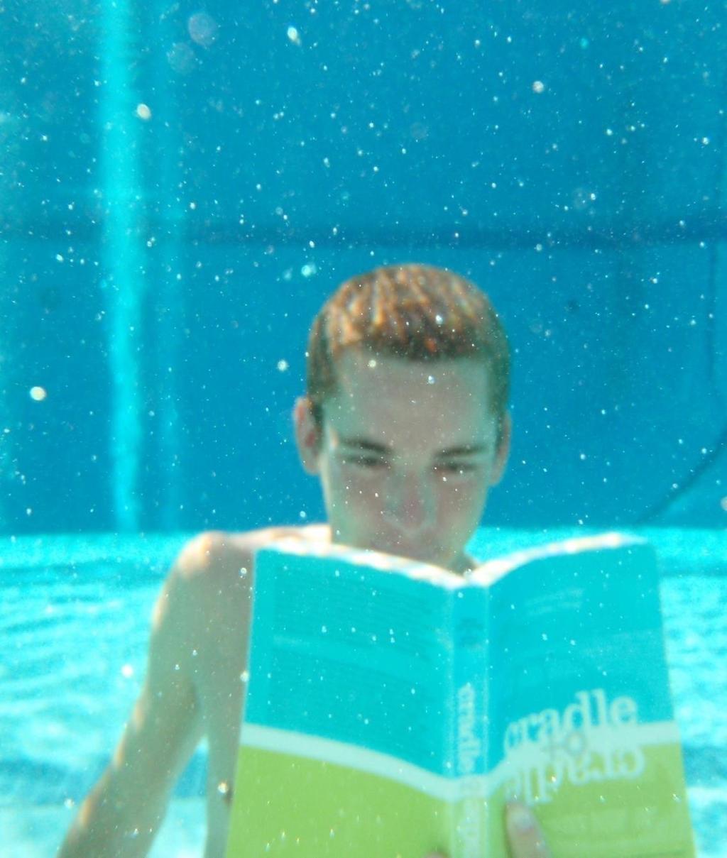 "A person with a book goes to the pool.