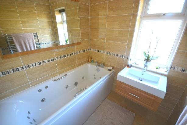 The property has a gabled entrance porch leading to a spacious entrance hallway with tiled flooring and impressive central staircase, a door then leads off to a downstairs cloakroom with contemporary