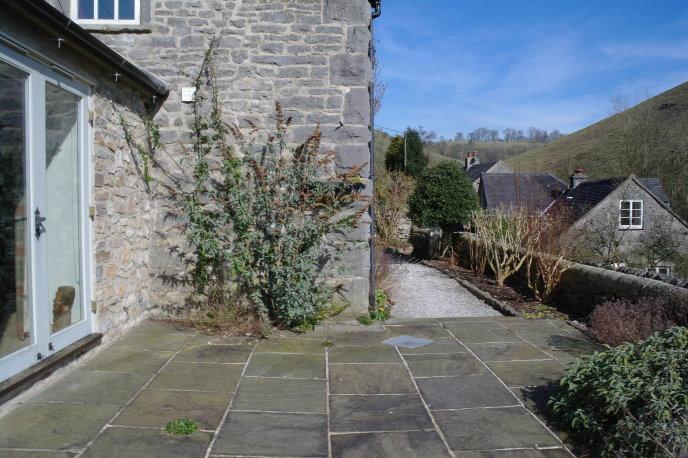 Gravelled to the front of the main entrance with steps to front entrance door and footpath to driveway. Also to the front is an attached, stone built store.